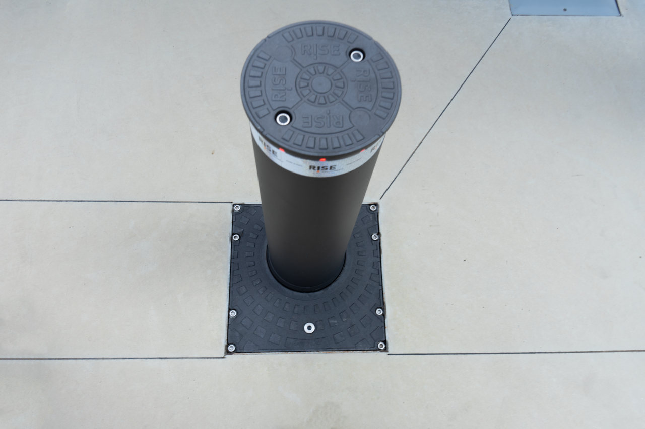 Dettaglio dall'alto di un dissuasore che protegge l'ingresso al cancello della ferramenta con magazzino